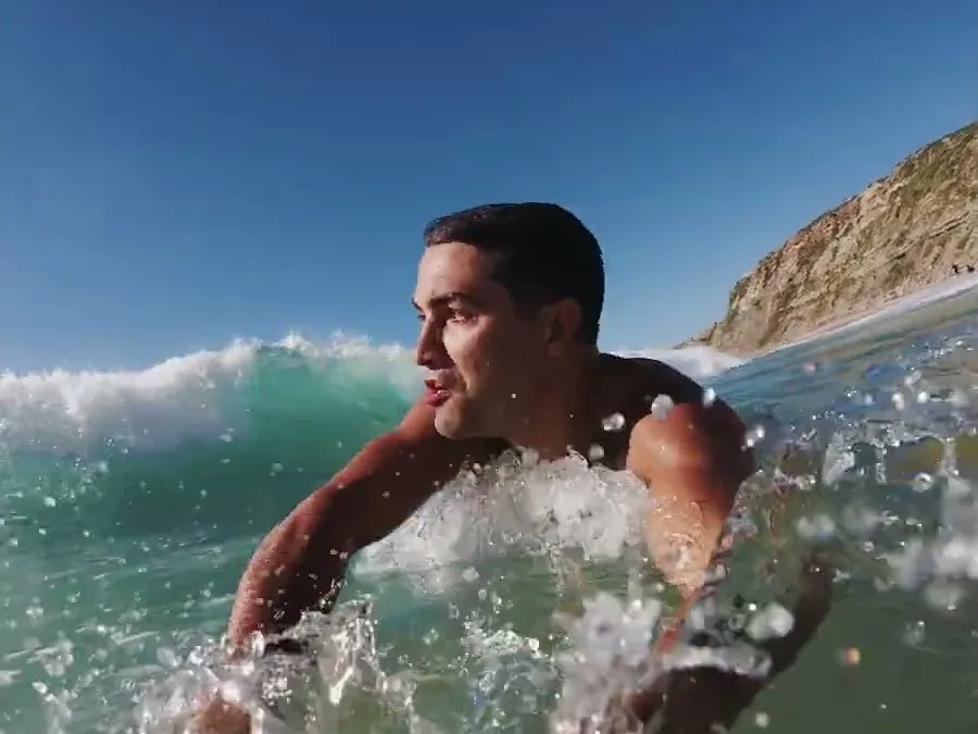 Rui Botelho swimming through a breaking wave, filmed for RVCA