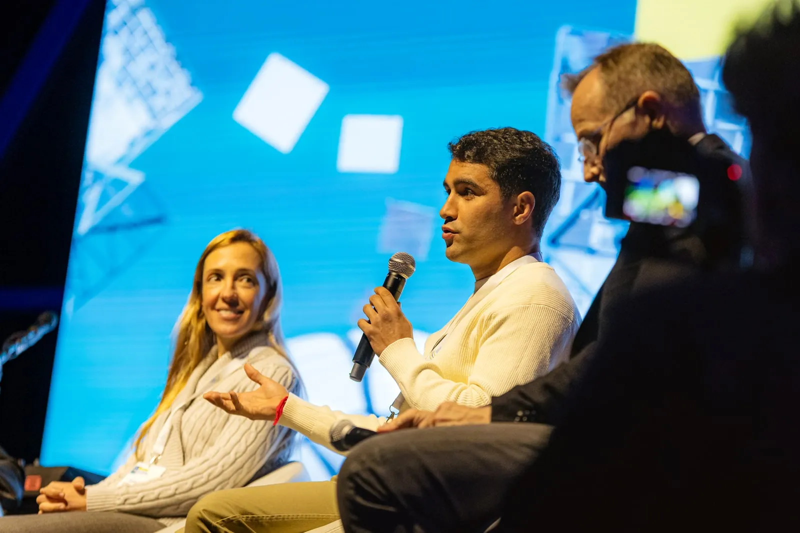 Rui Botelho speaking on stage with a microphone during a panel